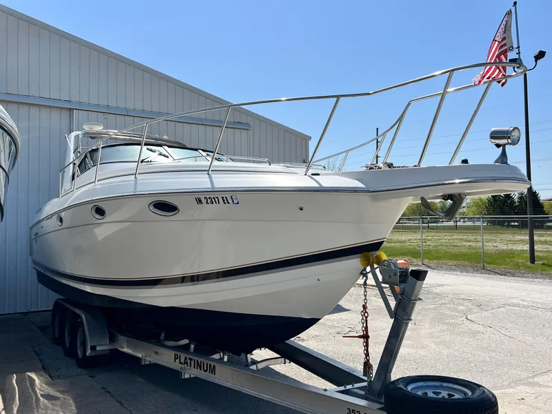 Slide: The Image of 1999 Formula 31 PC boat on trailer, parked outdoors near a building. - 3