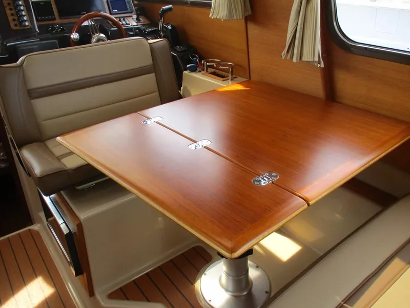 Slide: The Image of 2020 Ranger Tugs R-27 LE interior with wooden table and seating area. - 12