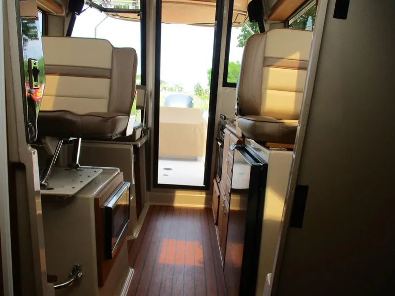 Slide: The Image of Interior of 2020 Ranger Tugs R-27 LE boat, featuring seating and wooden flooring. - 14