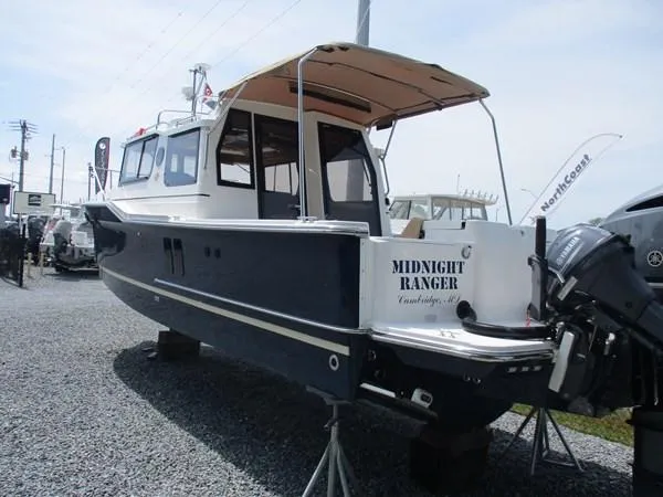 Slide: The Image of 2020 Ranger Tugs R-27 LE boat, "Midnight Ranger," displayed on gravel lot. - 2