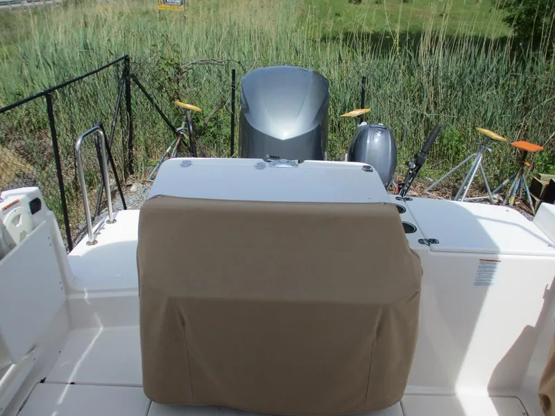 Slide: The Image of 2020 Ranger Tugs R-27 LE boat stern with covered seating and outboard motor. - 4