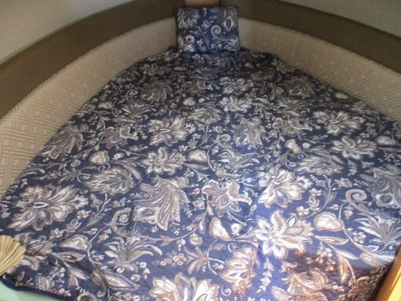 Slide: The Image of 2020 Ranger Tugs R-27 LE cabin bed with floral-patterned bedding. - 8