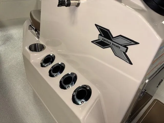 Slide: The Image of 2025 Xpress H22 Bay boat console with cup holders and logo detail. - 15