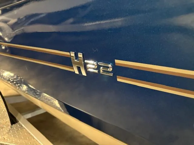 Slide: The Image of 2025 Xpress H22 Bay boat with sleek blue finish and metallic logo. - 23