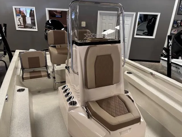 Slide: The Image of 2025 Xpress H22 Bay boat interior with tan seating and console in showroom. - 3