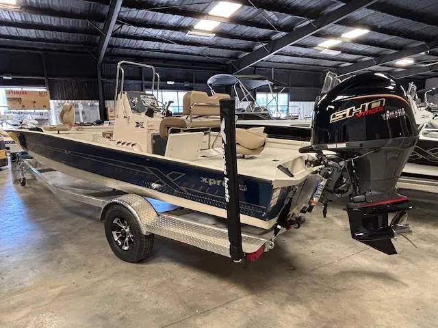 Slide: The Image of 2025 Xpress H22 Bay boat in showroom, featuring powerful outboard motor. - 5