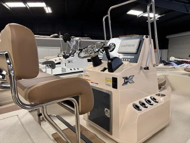 Slide: The Image of 2025 Xpress H22 Bay boat interior with Garmin navigation system and beige seating. - 8