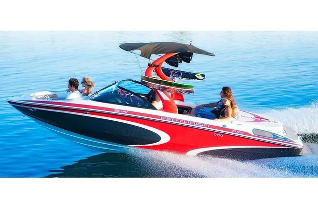 Slide: The Image of 2014 Centurion Enzo SS210 boat cruising on water with passengers and wakeboards. - 3