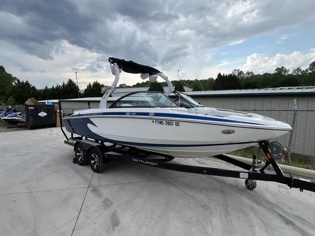 Slide: The Image of 2014 Centurion Enzo SS210 boat on trailer, parked outdoors under cloudy sky. - 6
