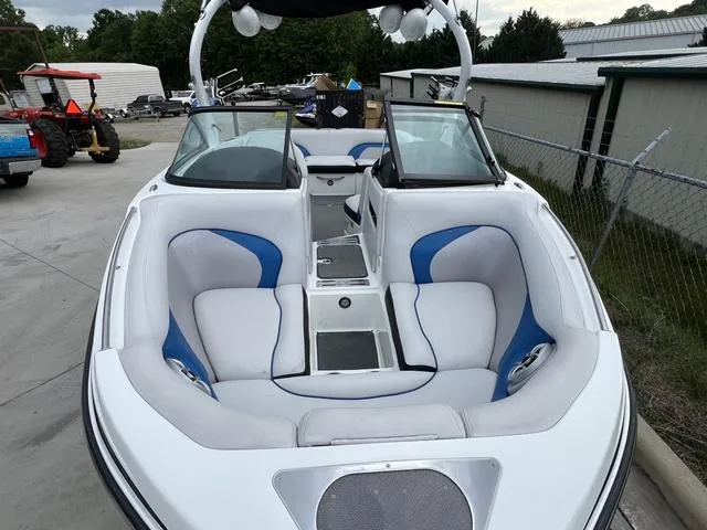 Slide: The Image of 2014 Centurion Enzo SS210 boat with white and blue interior, parked outdoors. - 7