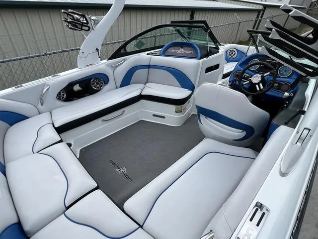 Slide: The Image of 2014 Centurion Enzo SS210 boat interior with white and blue seating, modern dashboard, and spacious layout. - 8