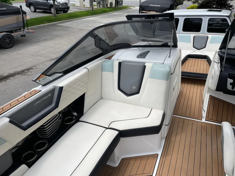Slide: The Image of 2019 Nautique Super Air Nautique G25 interior with white seating and teak flooring. - 11