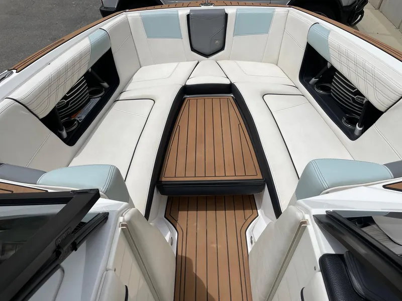 Slide: The Image of 2019 Nautique Super Air Nautique G25 boat interior with white seating and teak flooring. - 12