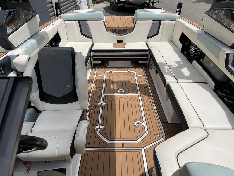 Slide: The Image of 2019 Nautique Super Air Nautique G25 interior with luxurious seating and teak flooring. - 13