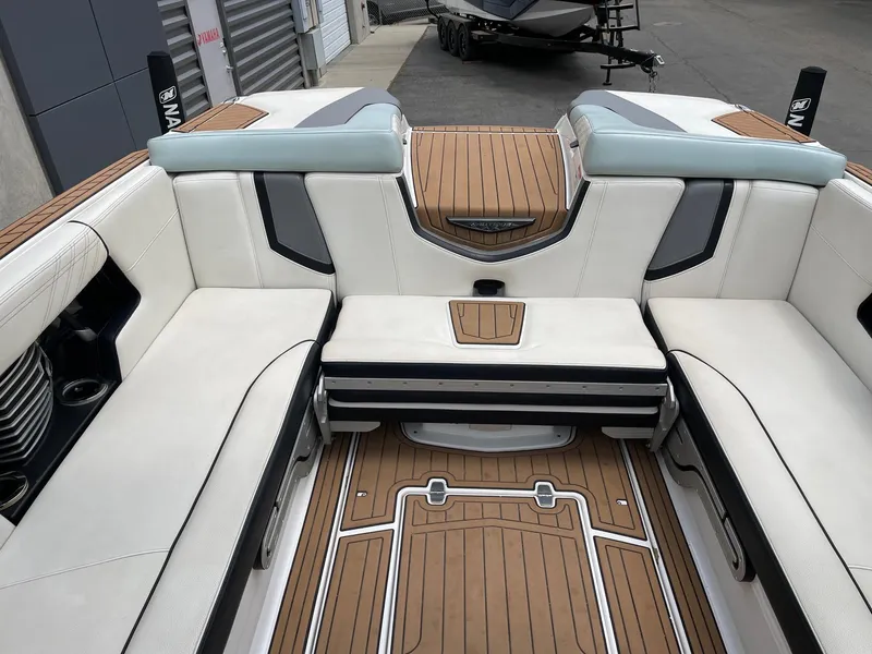 Slide: The Image of 2019 Nautique Super Air Nautique G25 interior with luxurious seating and teak flooring. - 9
