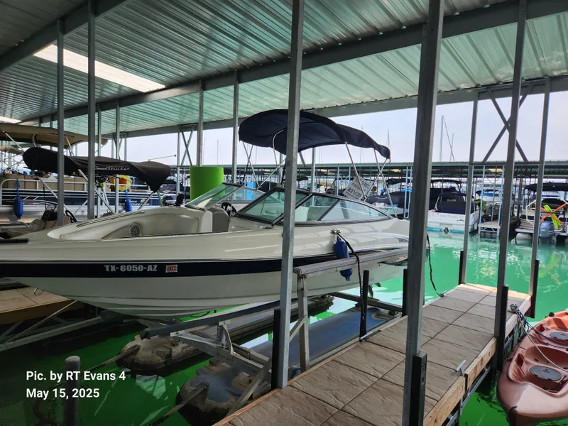 Slide: The Image of 2008 Caravelle 206LS Bow Rider docked in a marina under a covered structure. - 0