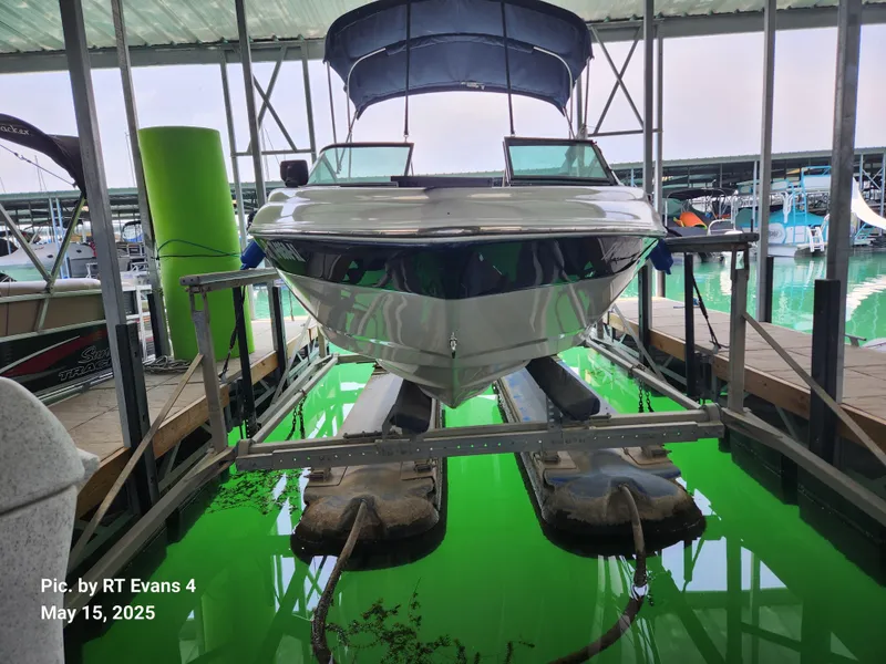 Slide: The Image of 2008 Caravelle 206LS Bow Rider on lift in marina, green water reflection. - 3