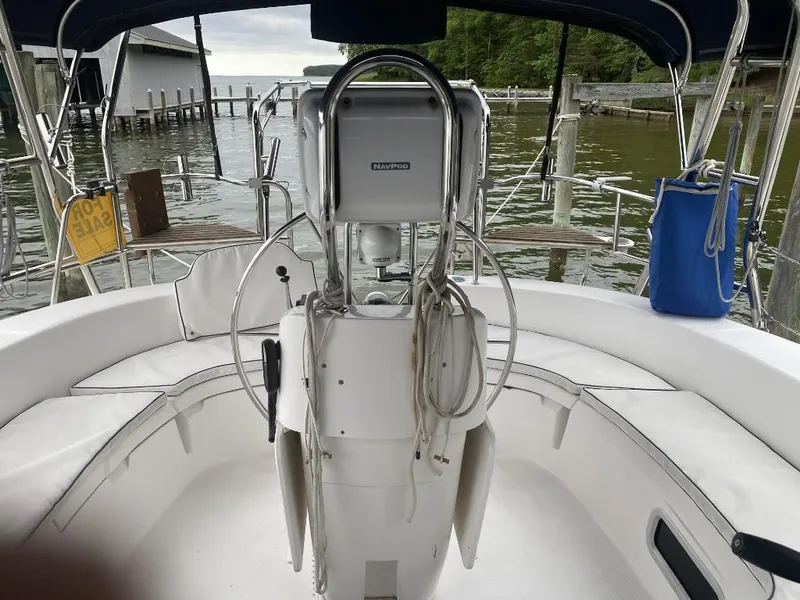 Slide: The Image of 2001 Hunter 410 sailboat cockpit with steering wheel, docked by a serene waterfront. - 11