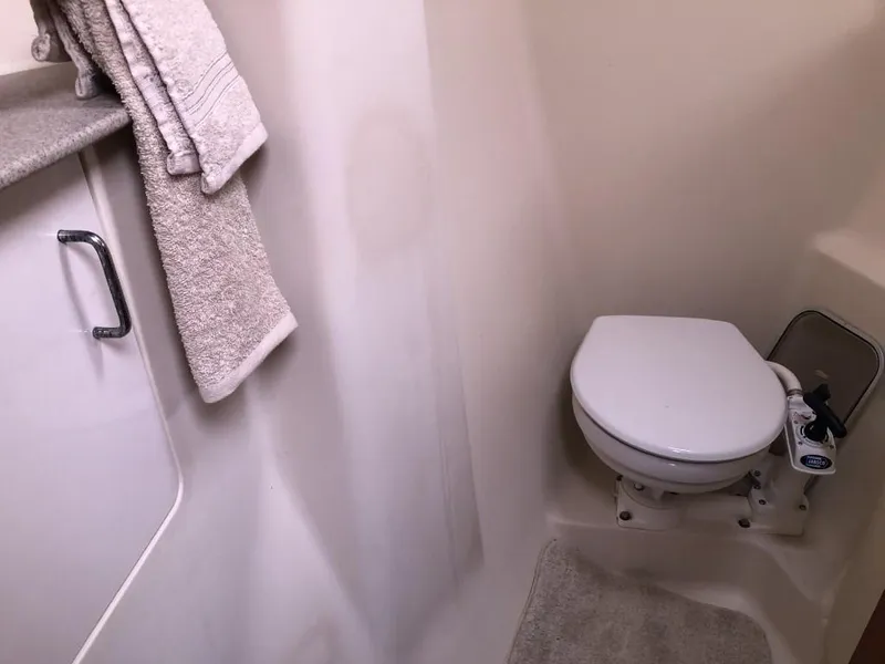 Slide: The Image of Compact bathroom in a 2001 Hunter 410 boat with toilet and towels. - 13