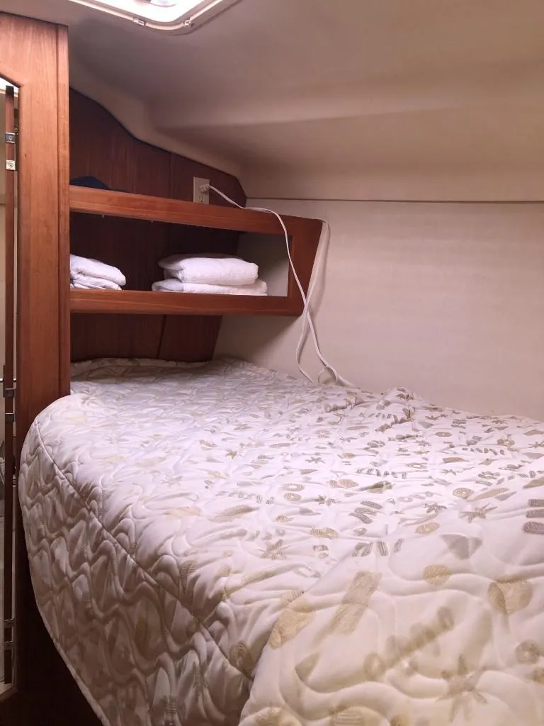 Slide: The Image of Cozy cabin interior of 2001 Hunter 410 sailboat with bed and wooden shelves. - 14