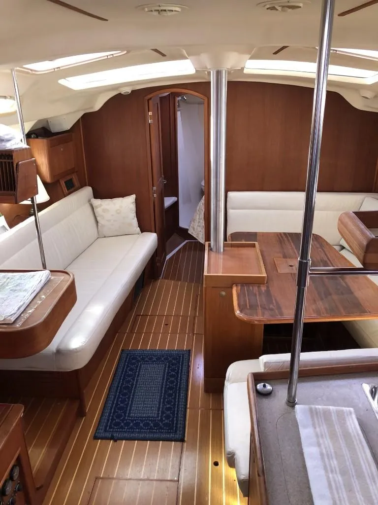 Slide: The Image of Interior of 2001 Hunter 410 sailboat with wood finish and cozy seating area. - 16