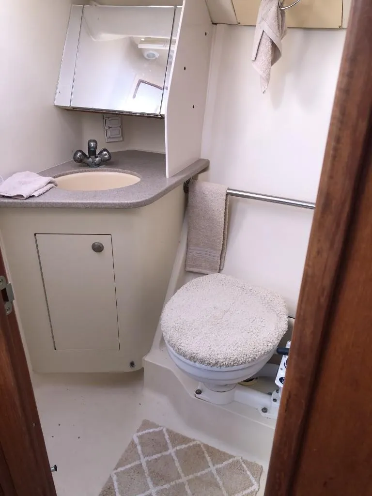 Slide: The Image of Compact bathroom in a 2001 Hunter 410 boat with sink, mirror, and toilet. - 19