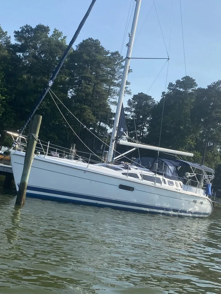 Slide: The Image of Sailboat on water, 2001 Hunter 410 model, docked near trees. - 2
