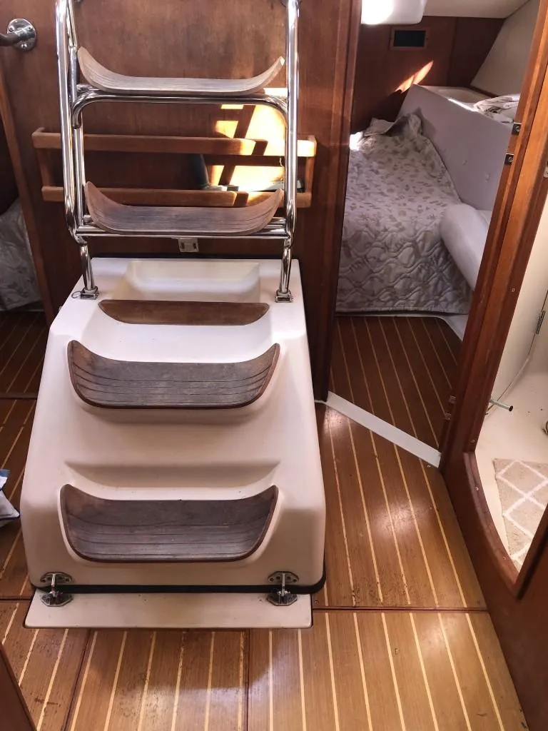 Slide: The Image of Interior of 2001 Hunter 410 sailboat with wooden steps and cozy cabin. - 21