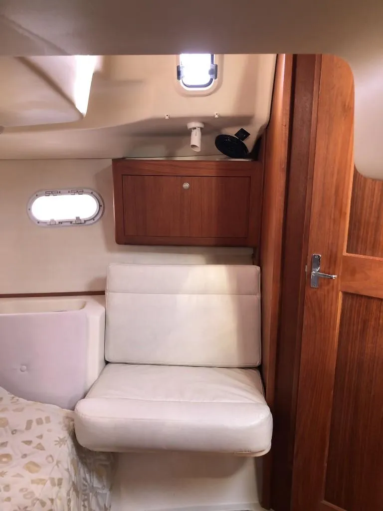 Slide: The Image of Interior of 2001 Hunter 410 sailboat with wooden cabinetry and white seating. - 24