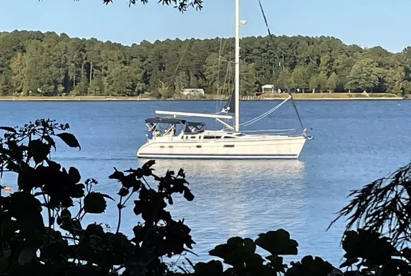 Slide: The Image of Sailboat Hunter 410 (2001) anchored on a serene lake with forested background. - 3