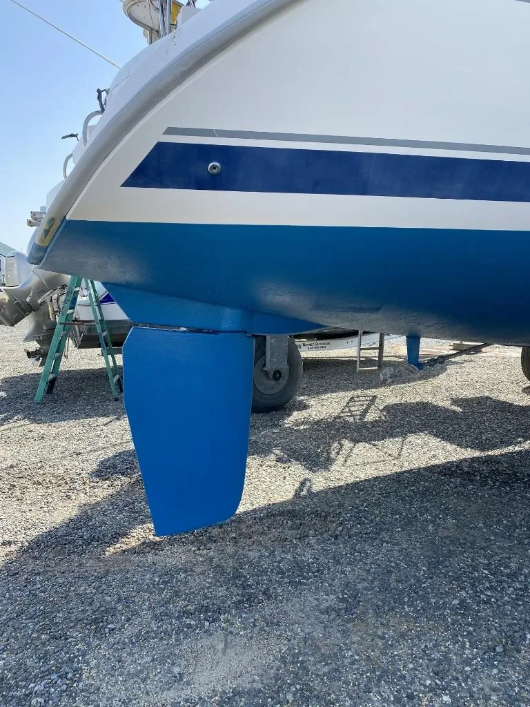 Slide: The Image of 2001 Hunter 410 sailboat keel on dry dock, blue and white hull. - 8