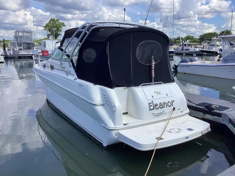 Slide: The Image of 2000 Sea Ray 270 Sundancer boat docked in a marina under cloudy skies. - 0