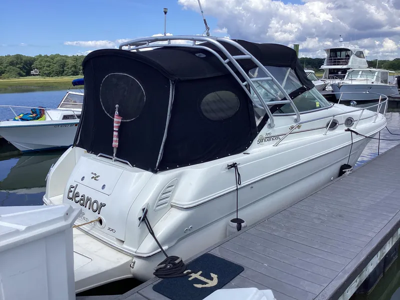Slide: The Image of 2000 Sea Ray 270 Sundancer boat docked, featuring a black canopy and white hull. - 1
