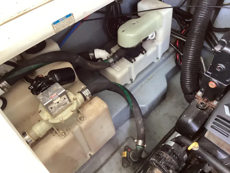 Slide: The Image of Engine compartment of a 2000 Sea Ray 270 Sundancer boat, showing mechanical components and hoses. - 11