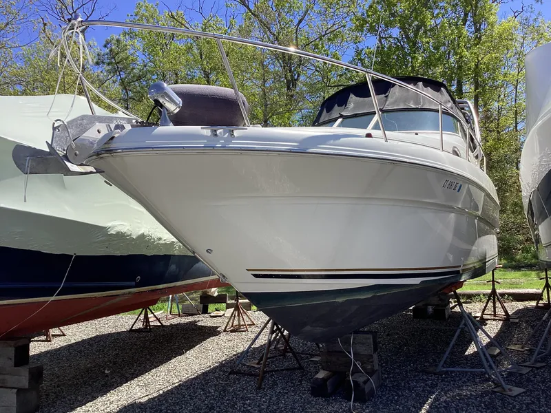 Slide: The Image of 2000 Sea Ray 270 Sundancer boat on stands, surrounded by trees. - 2