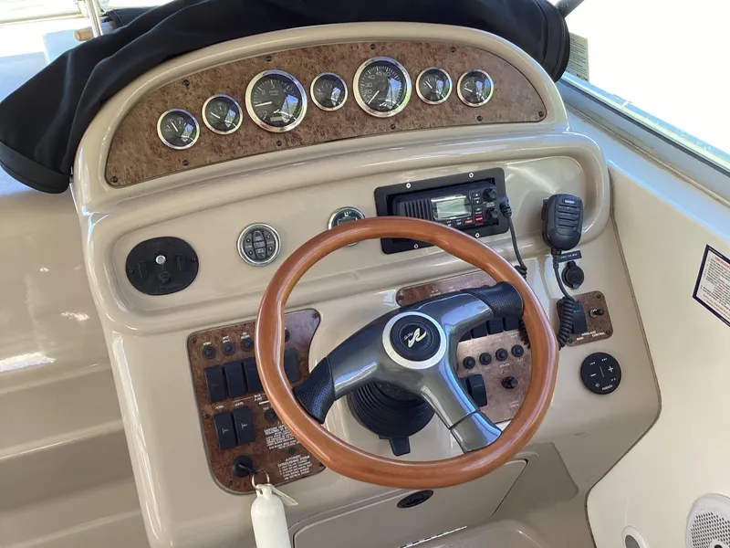 Slide: The Image of Dashboard of a 2000 Sea Ray 270 Sundancer boat with gauges and steering wheel. - 4