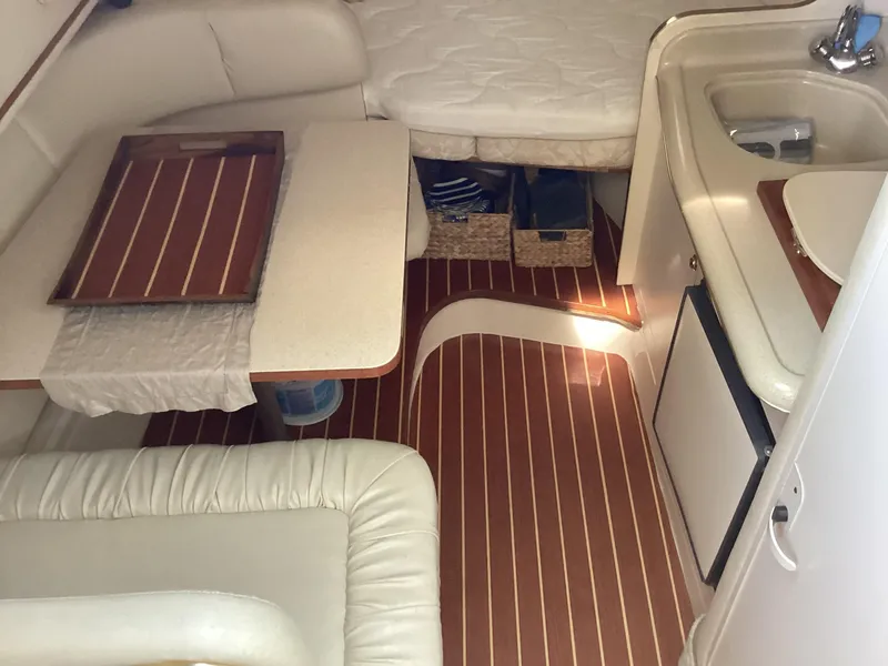Slide: The Image of Interior of 2000 Sea Ray 270 Sundancer with seating, table, and kitchenette. - 8