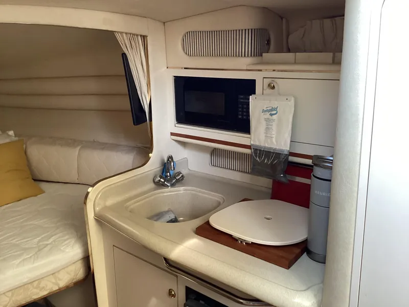 Slide: The Image of Interior of 2000 Sea Ray 270 Sundancer with kitchenette and cozy sleeping area. - 9