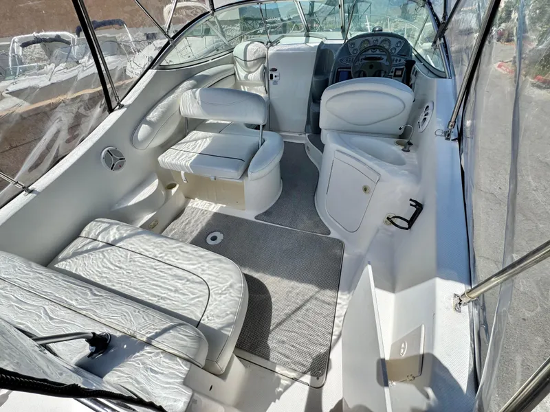Slide: The Image of 2004 Maxum 2500 SE boat interior with white seating and steering area. - 13