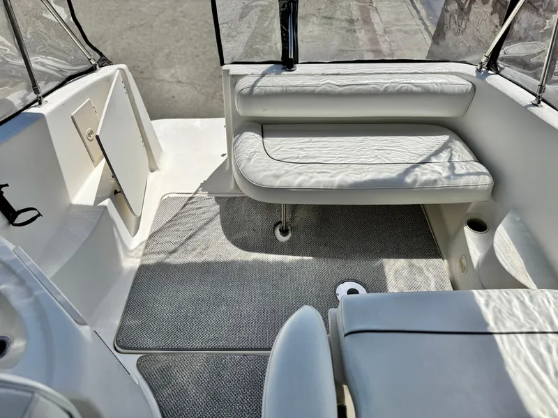 Slide: The Image of 2004 Maxum 2500 SE boat interior with white seating and carpeted floor. - 14