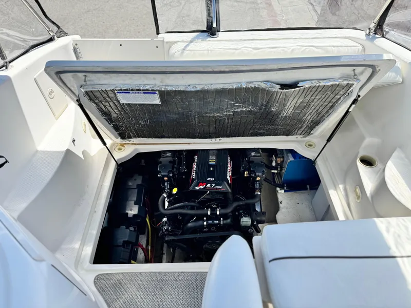 Slide: The Image of 2004 Maxum 2500 SE boat engine compartment with open hatch, showcasing engine details. - 15