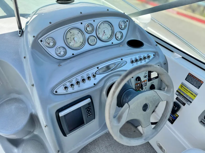 Slide: The Image of 2004 Maxum 2500 SE boat dashboard with gauges and steering wheel. - 26