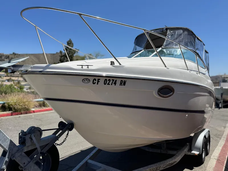 Slide: The Image of 2004 Maxum 2500 SE boat on trailer, parked outdoors under clear blue sky. - 3