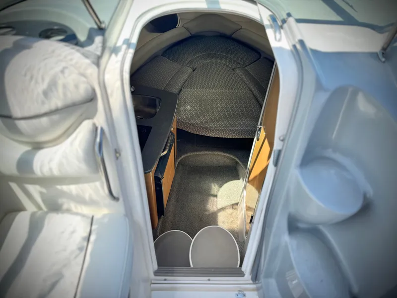 Slide: The Image of 2004 Maxum 2500 SE cabin interior with carpeted flooring and compact design. - 30