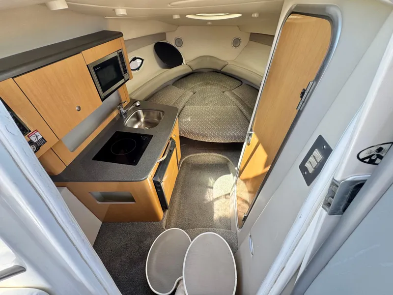Slide: The Image of 2004 Maxum 2500 SE cabin interior with kitchenette, sink, and seating area. - 31