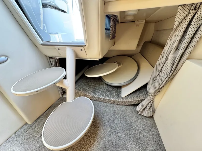 Slide: The Image of Interior of a 2004 Maxum 2500 SE boat with foldable tables and carpeted flooring. - 33