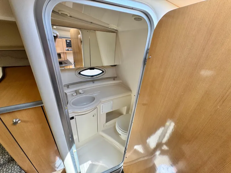 Slide: The Image of 2004 Maxum 2500 SE boat bathroom with sink, mirror, and wooden cabinetry. - 35