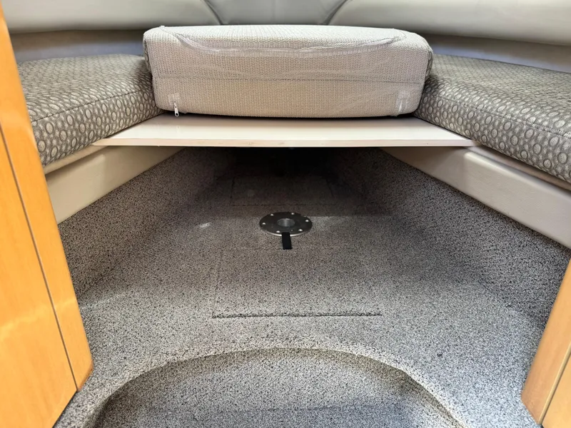 Slide: The Image of 2004 Maxum 2500 SE cabin interior with cushioned seating and carpeted flooring. - 37