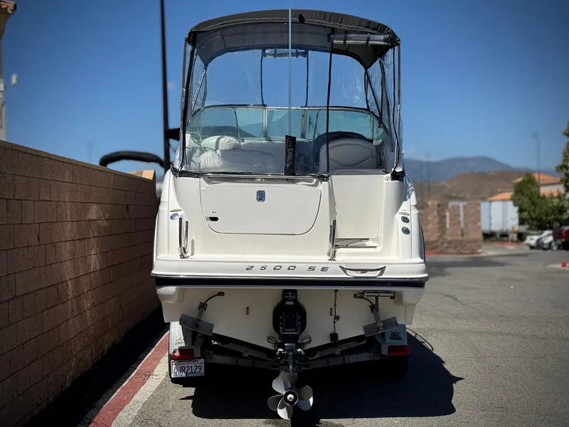 Slide: The Image of 2004 Maxum 2500 SE boat parked outdoors, rear view with canopy and propeller visible. - 4