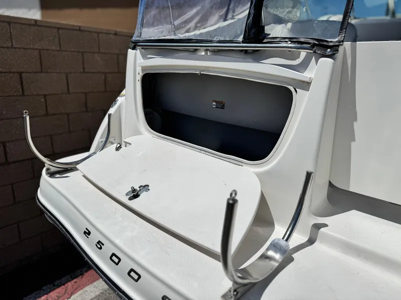 Slide: The Image of 2004 Maxum 2500 SE boat with open storage compartment and sleek design. - 7